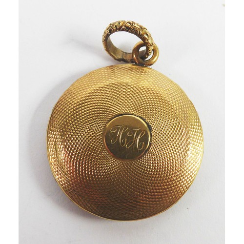 94 - VICTORIAN GOLD COLOURED METAL CIRCULAR PENDANT, the back engine turned, the glazed locket front encl... 