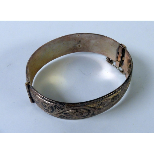 159 - SOLID STERLING HINGE-OPENING BANGLE with foliate scroll engraved top, 1 1/2ozs