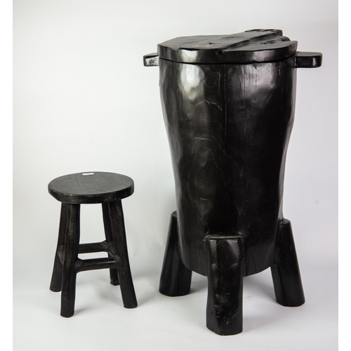 323 - MODERN EBONISED WOODEN DRUM SHAPED SEAT, crudely carved with hinged lid, lug handles and peg feet, 2... 