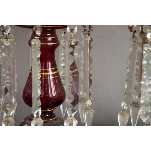 230 - PAIR OF RUBY GLASS TABLE LUSTRES, each of typical form with wavy rims and prism cut glass drops, pai... 