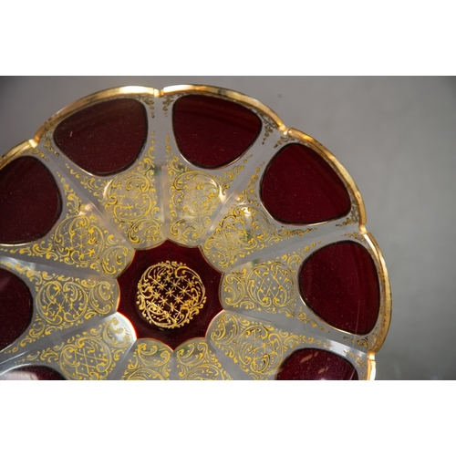 231 - PAIR OF BOHEMIAN RUBY OVERLAID AND GILT ETCHED PETAL PATTERN CIRCULAR DISHES, on tall tapering hexag... 