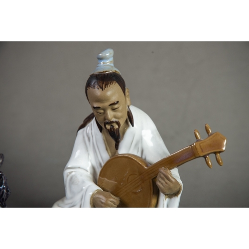 174 - CHINESE 20th CENTURY SEATED FIGURE OF A MUSICIAN playing a lute and having glazed robe and brown bis... 