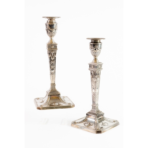 477 - PAIR OF VICTORIAN EMBOSSED AND WEIGHTED SILVER CANDLESTICKS, each of square, tapering form with urn ... 