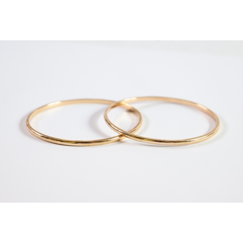 129 - PAIR OF GOLD COLOURED METAL BANGLES, 3in (7.6cm) diameter, 34.8gms, (marked 9ct and tests 9.9ct)