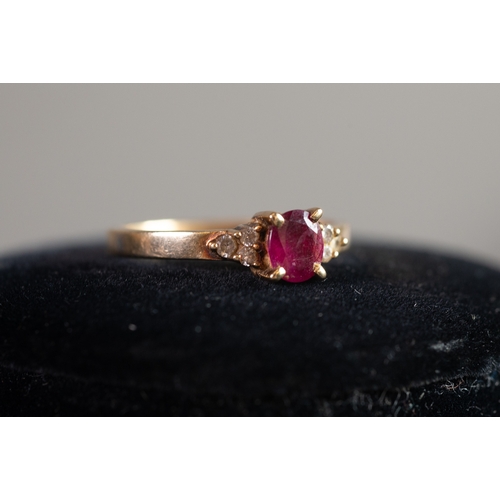 123 - 9ct GOLD RING set with a centre oval red stone and a trio of tiny diamonds to each shoulder, 2.2gms,... 