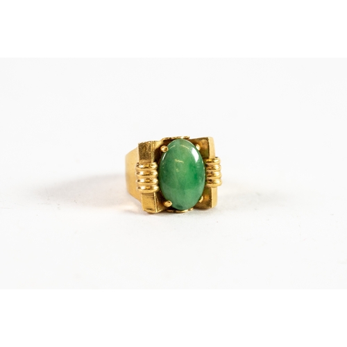 109 - CHINESE GOLD RING set with an oval green jade in an Art Deco cup setting, broad shank, 8.8gms gross,... 