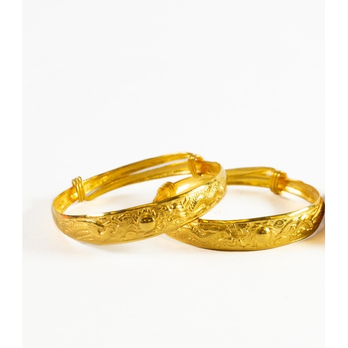 98 - PAIR OF CHINESE GOLD SLIDE-EXPANDING SPRUNG BANGLES, each repousse with a sun flanked by a pheonix a... 