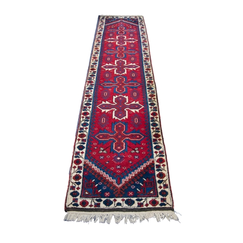 6 - TURKISH DOSEMEALTI RUNNER, with a row of seven propeller shaped medallions on a wine red field, with... 