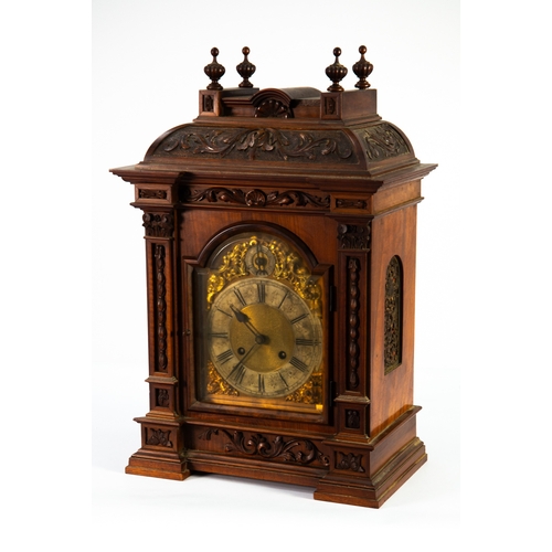 20 - EARLY TWENTIETH CENTURY GERMAN CARVED WALNUT CASED MANTLE OR BRACKET CLOCK, the brass Roman dial wit... 