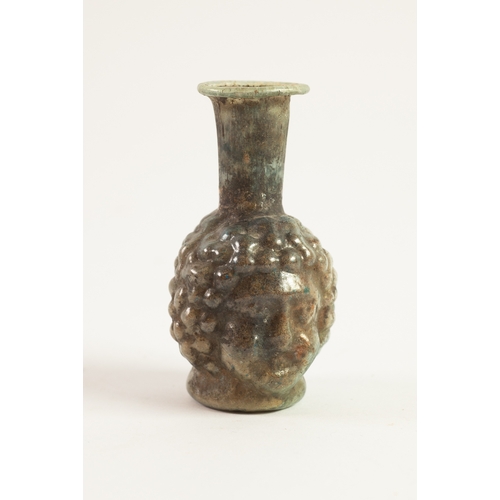 66 - ROMAN GLASS JANUS HEAD FLASK, circa 3rd Century AD, the flask globe and shaft shaped, with flat top ... 