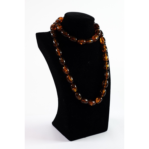 496 - SINGLE STRAND NECKLACE OF BROWN AMBER COLOURED GRADUATED OVAL BEADS with bayonet clasp, 36