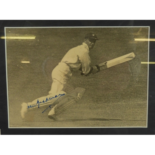 237B - SIGNED PHOTOGRAPH OF DON BRADMAN in action on the cricket field, signed in blue on right leg, approx... 