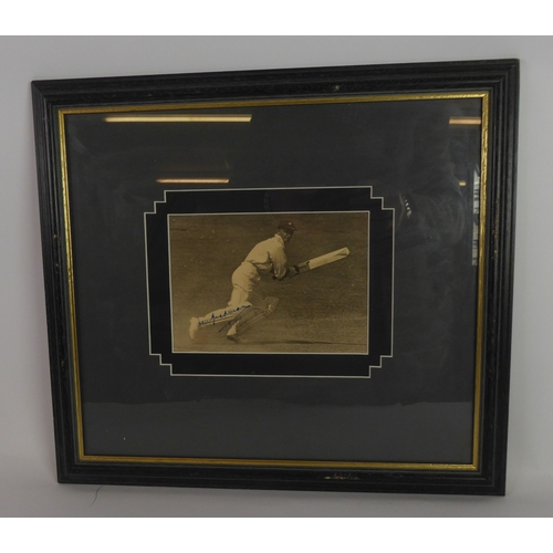 237B - SIGNED PHOTOGRAPH OF DON BRADMAN in action on the cricket field, signed in blue on right leg, approx... 