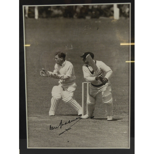 237C - SIGNED PHOTOGRAPH OF DON BRADMAN in action on the cricket field, signed in black, approximately 7 1/... 