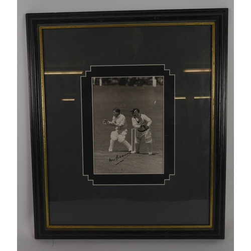 237C - SIGNED PHOTOGRAPH OF DON BRADMAN in action on the cricket field, signed in black, approximately 7 1/... 