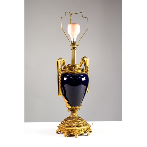 69 - GILT BRASS AND BLUE CERAMIC TABLE LAMP, of two handled pedestal urn form with leaf decoration and sc... 