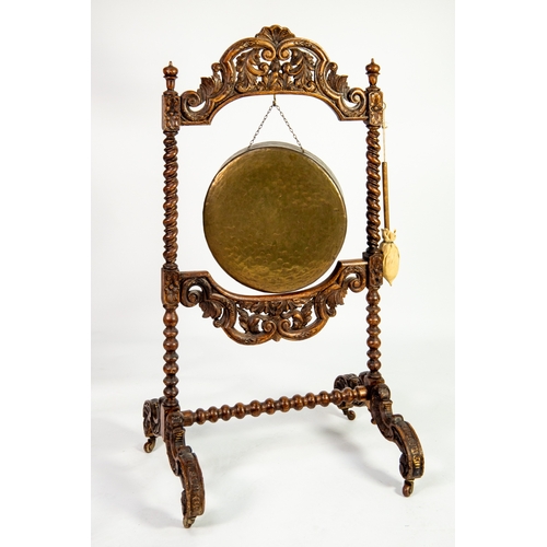 4 - NINETEENTH CENTURY HEAVILY CARVED OAK AND PLANISHED BRASS FLOOR STANDING DINNER GONG, the stand with... 