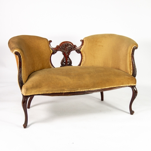 23 - VICTORIAN CARVED MAHOGANY CONVERSATION SOFA, the shaped back with central foliate scroll carved and ... 