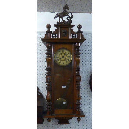 97 - A MAHOGANY CASED VIENNA SPRING DRIVEN WALL CLOCK, HAVING ROMAN NUMERAL DIAL AND HORSE PEDIMENT