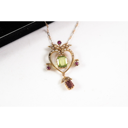 120 - EDWARDIAN GOLD HEART-SHAPED AND FOLIATE OPEN WORK PENDANT, set with seed pearls, a centre emerald cu... 