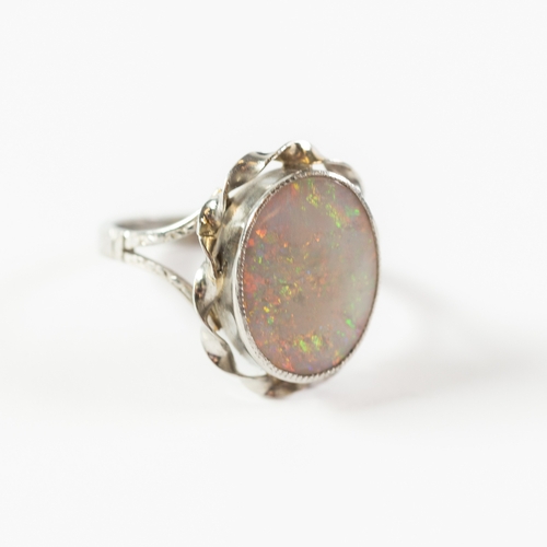 122 - PLATINUM RING, collet set with an oval opal, spirally twisted lower surround, ring size N, 5.5gms