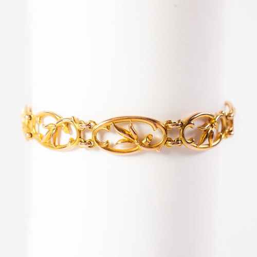 90 - EDWARDIAN 15ct GOLD BRACELET, with eight rococo scroll openwork oval links, with foliate sprig centr... 