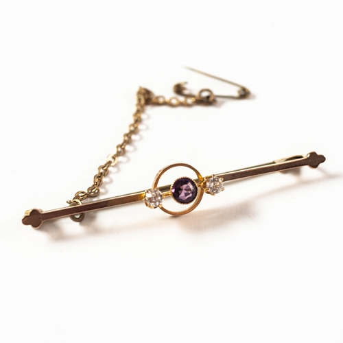 105 - 9ct GOLD BAR BROOCH with open work circular centre collet set with a centre amethyst flanked by two ... 