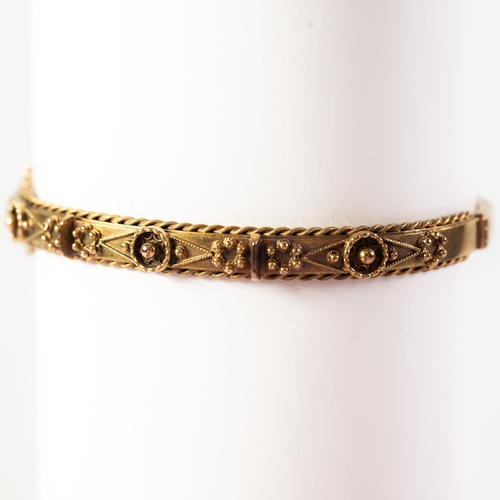 106 - VICTORIAN 15ct GOLD NARROW HOLLOW BANGLE, hinge-opening, the top embossed with applied decoration an... 