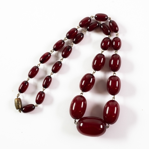 72 - SINGLE STRAND NECKLACE OF GRADUATED OVAL DARK RED AMBER BEADS, 20