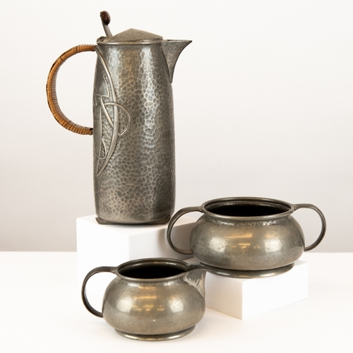 104 - ARCHIBALD KNOX ‘TUDRIC’ PEWTER 1 ¾ PINT HOT WATER JUG, (0231), with woven vane handle and bakelite? ... 