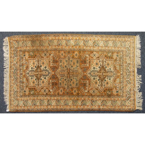 31 - INDIAN HAND-WOVEN WOOL RUG OF TURKOMAN DESIGN, in brick red, pale green and off-white, with three la... 