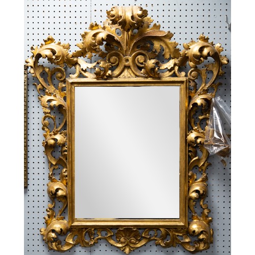 137 - NINETEENTH CENTURY ITALIAN CARVED GILTWOOD WALL MIRROR, the oblong plate housed within a moulded sli... 