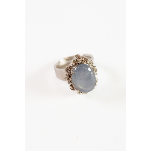 215 - 14k WHITE GOLD DRESS RING SET WITH A CABOCHON STAR SAPPHIRE SHOWING 'SIX RAY ASTERISM' within cluste... 