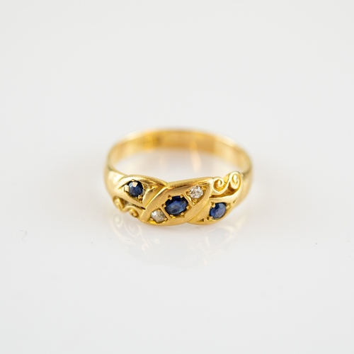 89 - VICTORIAN 18ct GOLD RING with a chased scroll setting with three small sapphires and two tiny diamon... 