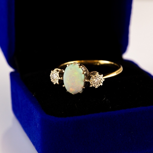 169 - 18ct GOLD RING, set with centre oval opal flanked by two diamonds in deceptive settings, each approx... 