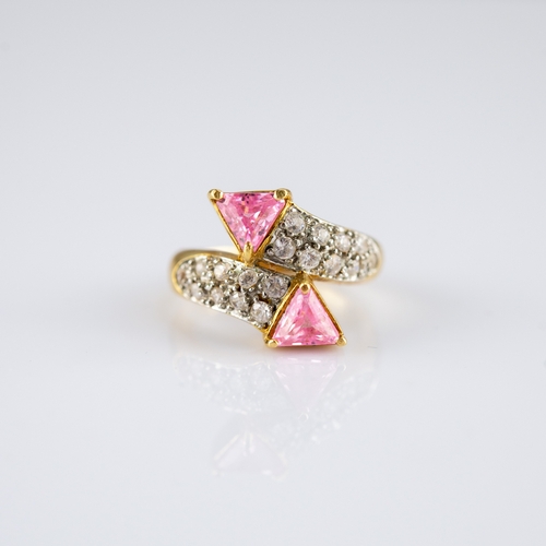 159 - GOLD COLOURED METAL CROSS-OVER RING, set with twenty small white stones and two triangular pink ston... 