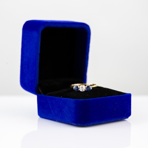 59 - 18ct GOLD AND PLATINUM RING, set with a centre round brilliant cut diamond, flanked by two round blu... 