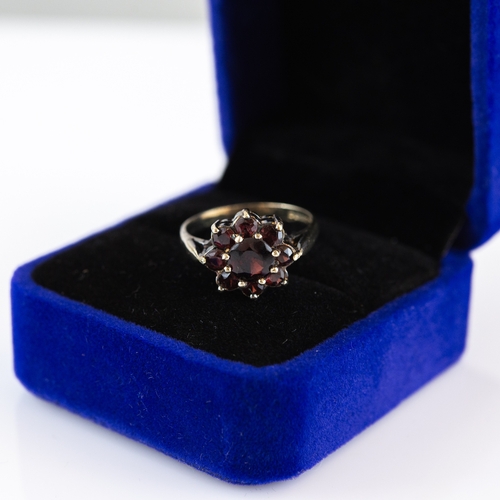 60 - SILVER GILT AND GARNET DAISY CLUSTER RING, ring size N/O