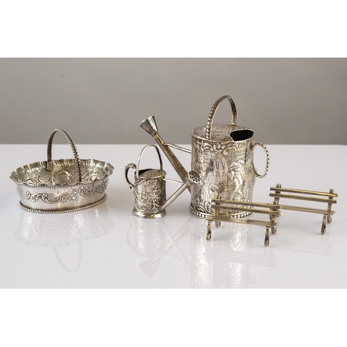 274 - THREE MINIATURE PIECES OF FOREIGN EMBOSSED SILVER COLOURED METAL, comprising: TWO WATERING CANS, one... 