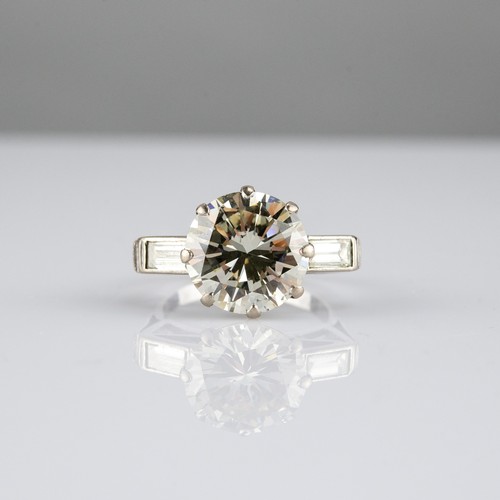 167 - PLATINUM RING SET WITH A LARGE ROUND BRILLIANT CUT SOLITAIRE DIAMOND, approximately 9.75ct, with a b... 