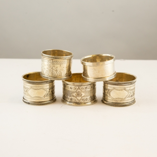 315 - FIVE VICTORIAN AND LATER SILVER NAPKIN RINGS, including a pair and a modern plain example, of heavy ... 