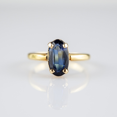 138 - 18ct GOLD RING with an oval synthetic sapphire in a four claw setting, 3.5gms, ring size 'P/Q'