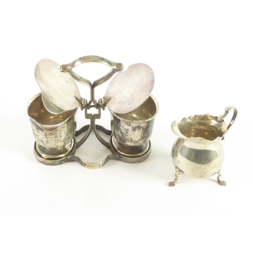 641 - SMALL EDWARDIAN SILVER PYRIFORM CREAM JUG with double 'C' scroll handles and raised on three scroll ... 