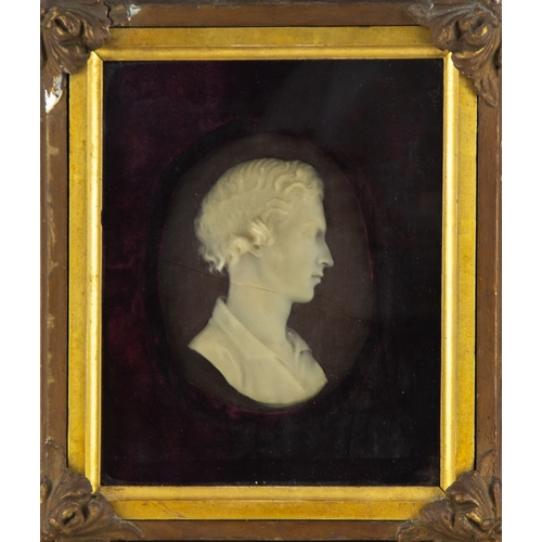 654 - 19TH CENTURY WAX CAMEO BUST OF A YOUNG MAN with curly hair and open shirt, white on a purple ground,... 