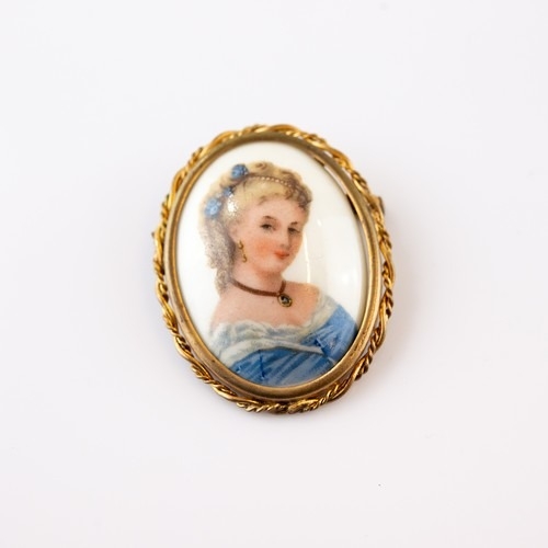 690 - VINTAGE GILT METAL AND LIMOGES PORCELAIN OVAL BROOCH, painted with the bust of a lady in blue gown