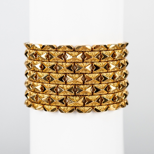 51 - 18ct GOLD BROAD CUFF BRACELET with each panel link having two opposed polished chevrons on a foliate... 