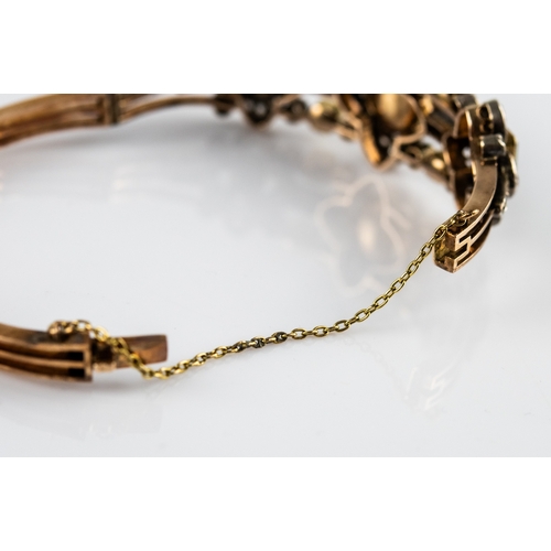 39 - EARLY 19th CENTURY GOLD AND WHITE GOLD TRIPLE STRAND HINGE-OPENING OVAL BANGLE, the top with 7 colle... 