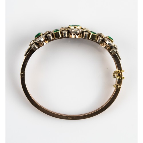 39 - EARLY 19th CENTURY GOLD AND WHITE GOLD TRIPLE STRAND HINGE-OPENING OVAL BANGLE, the top with 7 colle... 