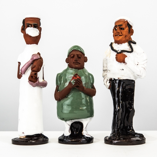 87 - THREE 'CHELSEA POTTERY' IN PART GLAZED TERRA COTTA MEDICAL FIGURES, respectively a DOCTOR holding a ... 