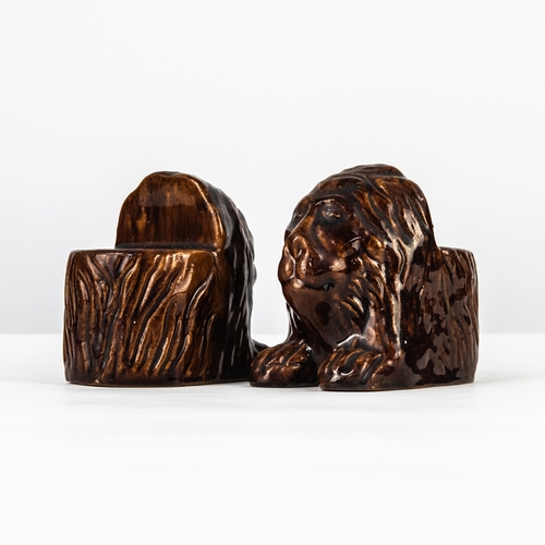 96 - PAIR OF NINETEENTH CENTURY TREACLE GLAZED MOULDED POTTERY SASH WINDOW STOPS, each modelled as a lion... 